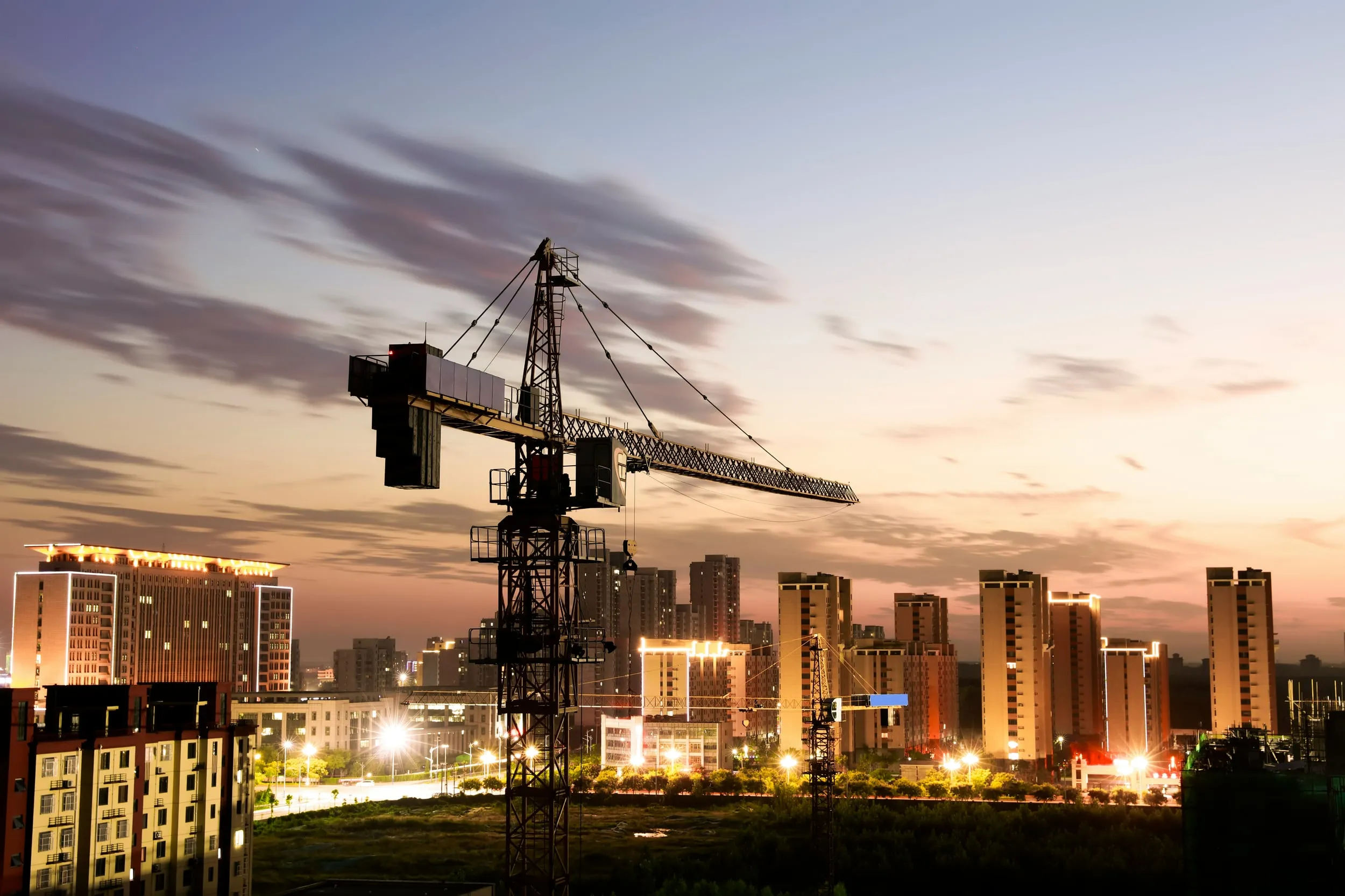 Gru di cantiere su skyline al crepuscolo